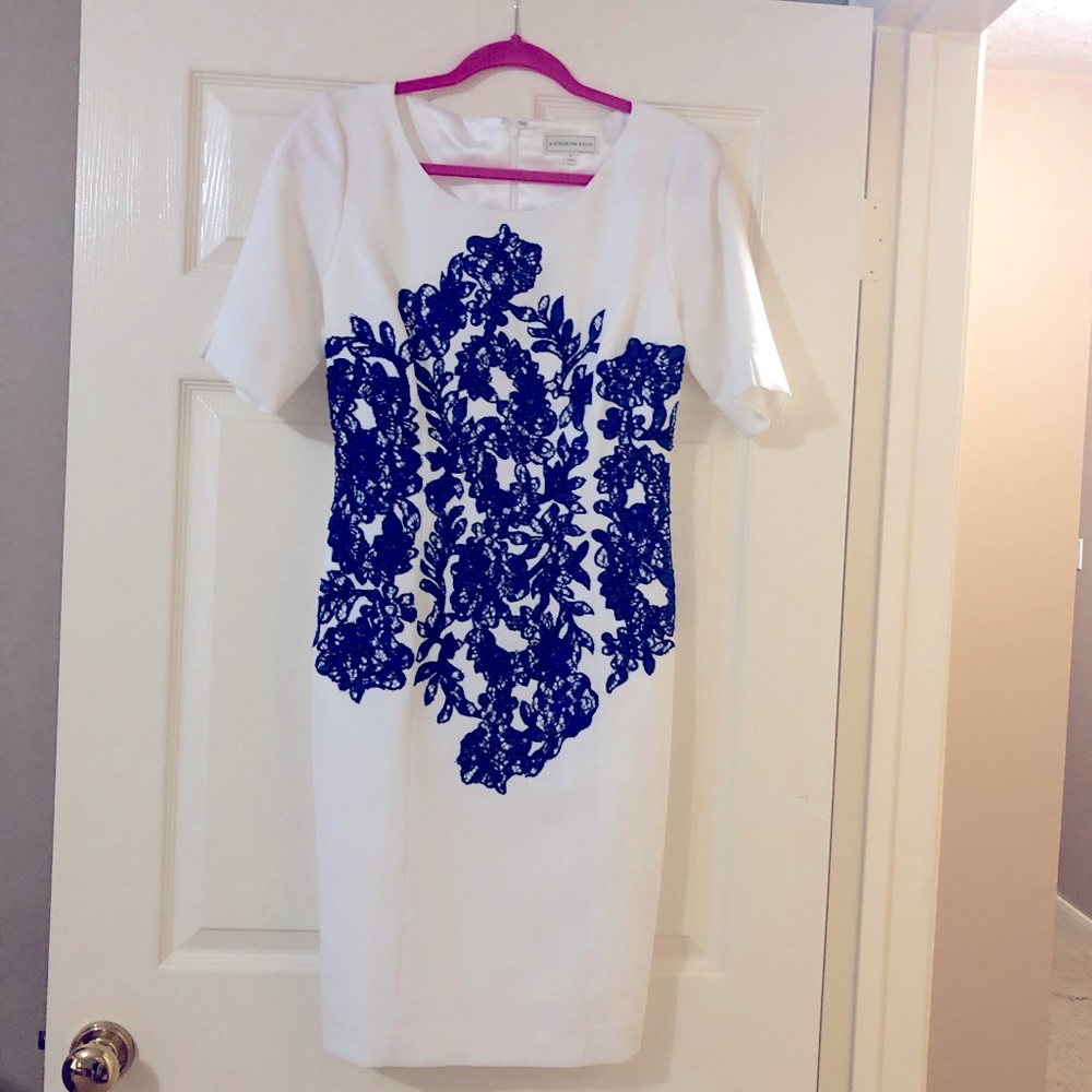 White dress with embroidered blue design.